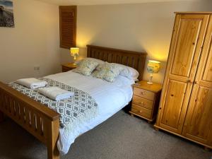 ein Schlafzimmer mit einem Bett mit zwei Nachttischen und zwei Lampen in der Unterkunft Northness Apartments, Lerwick Self Contained in Lerwick