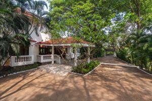 a house with a pathway leading to the front yard at SaffronStays Chikoo Wadi- 3BDR Pet-friendly Villa with Pool in Boisar in Boisar