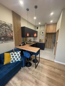a kitchen with a blue couch and a wooden table at Łódź4HOME Apartament in Łódź