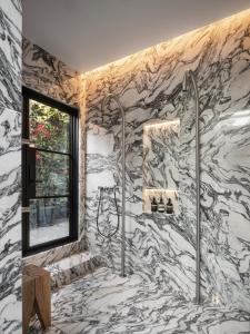 a bathroom with a marble shower with a window at Angelo in Los Angeles