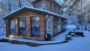 a log cabin in the snow with a yard at Seychellen House in Großenkneten