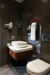 a bathroom with a sink and a toilet and a mirror at Nova Plaza Crystal Hotel & Spa in Istanbul
