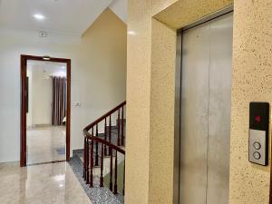 un pasillo con una puerta corredera de cristal y una escalera en Hotel trung hiếu en Ha Long