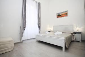 Habitación blanca con cama y ventana en Brillante Appartamento di Sara, en Anzio