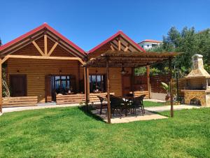 a wooden cabin with a table and chairs in the yard at Chalet edelweiss preveza in Preveza