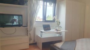 a bedroom with a desk with a laptop on it at Cozy villa, close to the center of Bucharest. in Bragadiru