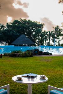 uma mesa branca com duas taças e copos. em Diamonds Leisure Beach & Golf Resort em Praia de Diani