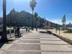 un trottoir avec des palmiers et une rue avec des bâtiments dans l'établissement Apto en Pocitos cerca a La Rambla para 4 personas, à Montevideo