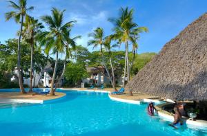 a swimming pool with palm trees and a resort at Diamonds Leisure Beach & Golf Resort in Diani Beach