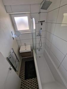 a bathroom with a tub and a sink and a window at Cozy room - Only room in London