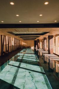 a swimming pool with benches in a building at Aethos Monterosa in Champoluc