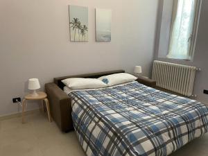 a bedroom with a bed with a plaid blanket at Azzurra House in Marina di Pisa