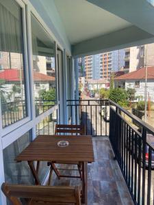 a balcony with a wooden table and two chairs at Hotel Sonata in Batumi