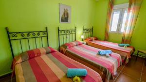 three beds in a room with green walls at Buenavista de Illora Íllora by Ruralidays in Illora