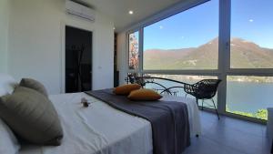 Top Lake View في Faggeto Lario : غرفة نوم بسرير ونافذة كبيرة
