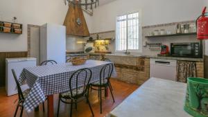 kuchnia ze stołem i krzesłami w kuchni w obiekcie Casa rural Navalonguilla Santa Olalla del Cala by Ruralidays w mieście Almadén de la Plata