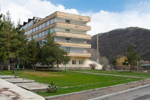 a building with a grass yard in front of it at Jermuk Ararat Health SPA in Jermuk