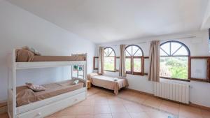 a bedroom with two bunk beds and two windows at Santa Marta Archidona by Ruralidays in Archidona +41 photos