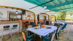 une salle à manger avec une table, des chaises et une cheminée dans l'établissement Cortijo la Algallumbilla Carcabuey by Ruralidays, à Carcabuey