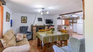 ein Wohnzimmer mit einem Tisch und einer Küche in der Unterkunft Cortijo Palitroques Carcabuey by Ruralidays in Carcabuey