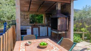 una cocina al aire libre con mesa y horno en Cortijo Palitroques Carcabuey by Ruralidays, en Carcabuey