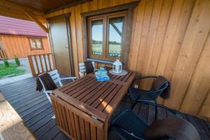 a wooden table and chairs on a porch of a cabin at Dreamland skorupki in Ryn