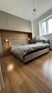 ein Schlafzimmer mit einem großen Bett und Holzboden in der Unterkunft Rezidencia pod Zámkom Bojnice in Bojnice