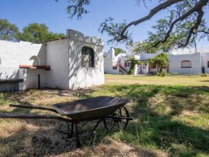 a wheelbarrow sitting in the grass next to a building at Pampa Cottage 