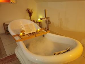 a bath tub with a book and candles in it at Les lits de l'Arz in Malansac