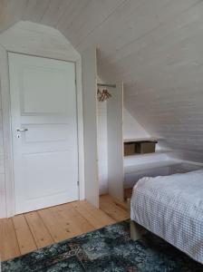 a bedroom with a white door and a bed in a room at Domki skowronki in Filipów
