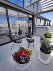 a balcony with flowers and chairs on a building at Gazi pool house in Athens