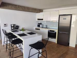 una cocina con armarios blancos y electrodomésticos negros en Gazi pool house en Athens