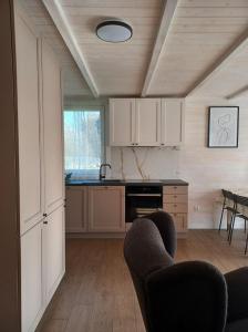 a kitchen with white cabinets and chairs in a room at Domki skowronki in Filipów