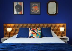 una camera con un letto con una parete blu e due lampade di Villa Casa Mia - BY PRIMO C0NCIERGERIE a Simandre