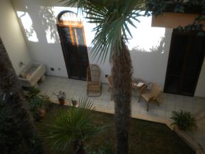 a courtyard with a palm tree and chairs and a door at Federico II in Brindisi