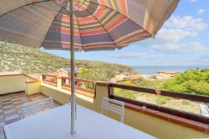 a table with an umbrella on top of a balcony at La Bella Vista in Buggerru