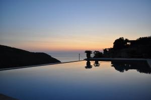 a swimming pool with a sunset in the background at Villa Pebbles in Trikovilón +78 photos