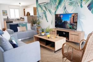 ein Wohnzimmer mit einem Sofa und einem Flachbild-TV in der Unterkunft Villa Casa Mia - BY PRIMO C0NCIERGERIE in Simandre