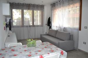 un salon avec une table et un canapé dans l'établissement Becky's House casa vacanze, à Quartu SantʼElena