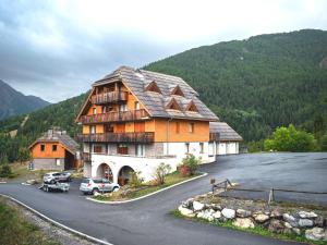 un grand bâtiment avec une voiture garée dans un parking dans l'établissement Appartement Uvernet-Fours, 3 pièces, 8 personnes - FR-1-504-7, à Uvernet