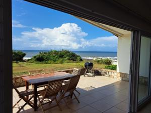 a table and chairs on a patio with a view of the ocean at Diljaroon, 1331 Frances Avenue, Ramsgate in Ramsgate