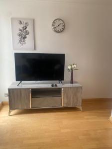 a large entertainment center with a flat screen tv at Cozy two bedroom flat in the heart of London in London