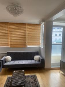 a living room with a couch and a window at Cozy two bedroom flat in the heart of London in London