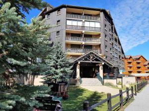 um grande edifício de apartamentos com uma escada em frente em Appartement La Joue du Loup, 2 pièces, 7 personnes - FR-1-504-76 em Le Dévoluy