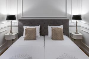 a bedroom with a large white bed with two lamps at Belle Boutique in Sliema