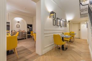 a dining room with yellow chairs and a table at Belle Boutique in Sliema