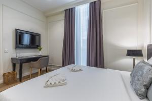 a bedroom with a bed and a desk and a television at Belle Boutique in Sliema