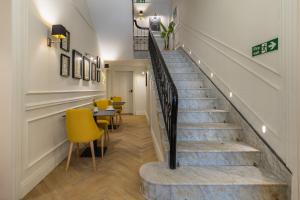 a staircase with yellow chairs and a table in a room at Belle Boutique in Sliema