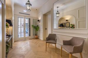 a hallway with two chairs and a mirror at Belle Boutique in Sliema