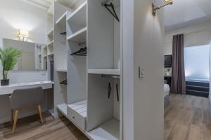 a walk in closet with white cabinets and a chair at Belle Boutique in Sliema